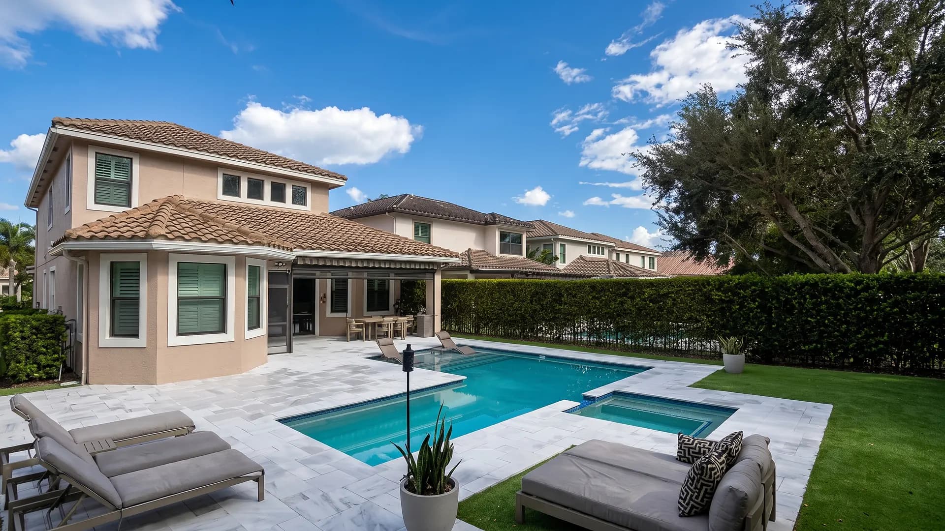 Large stone pool deck with lounge chairs