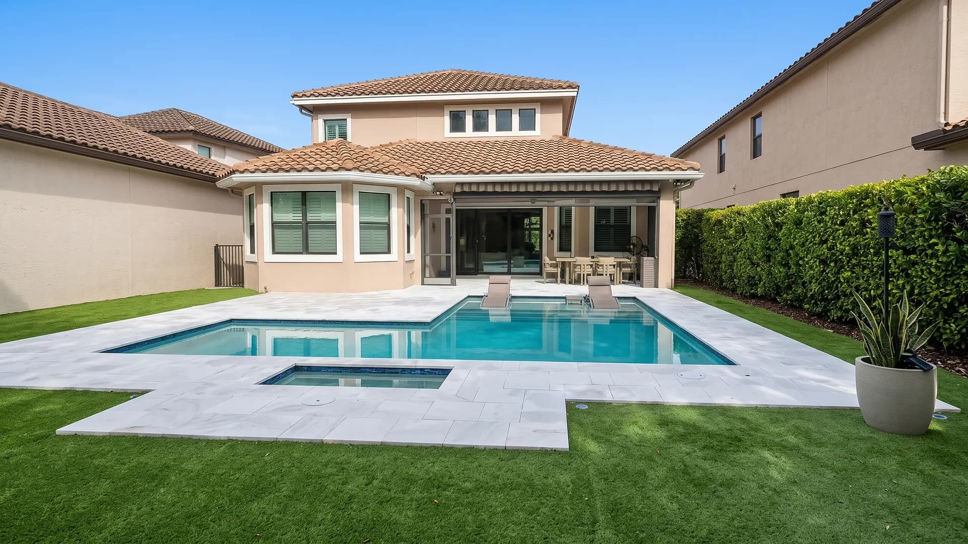Artificial turf lawn next to a stone pool deck