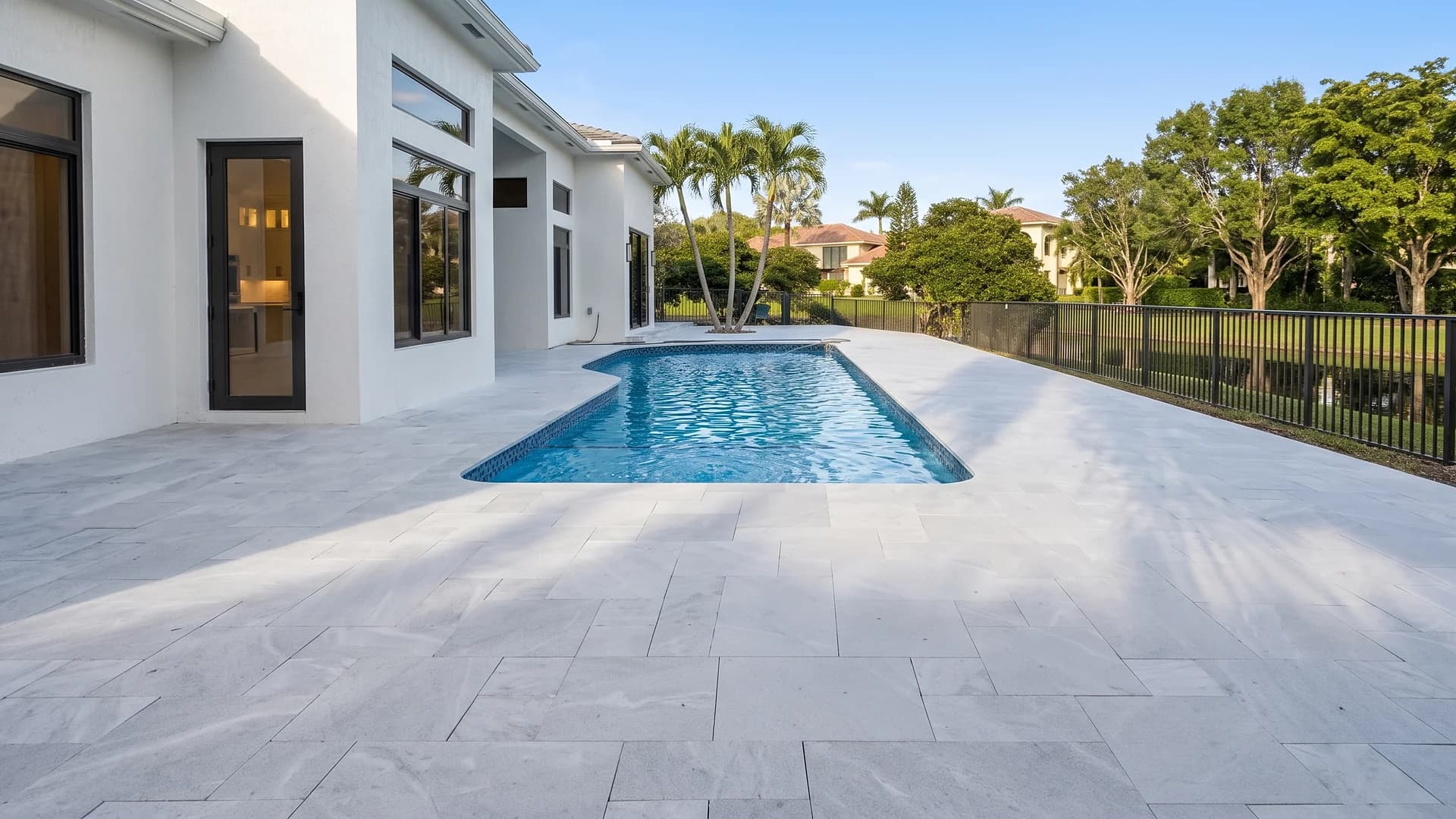 Light stone pool deck at a modern home