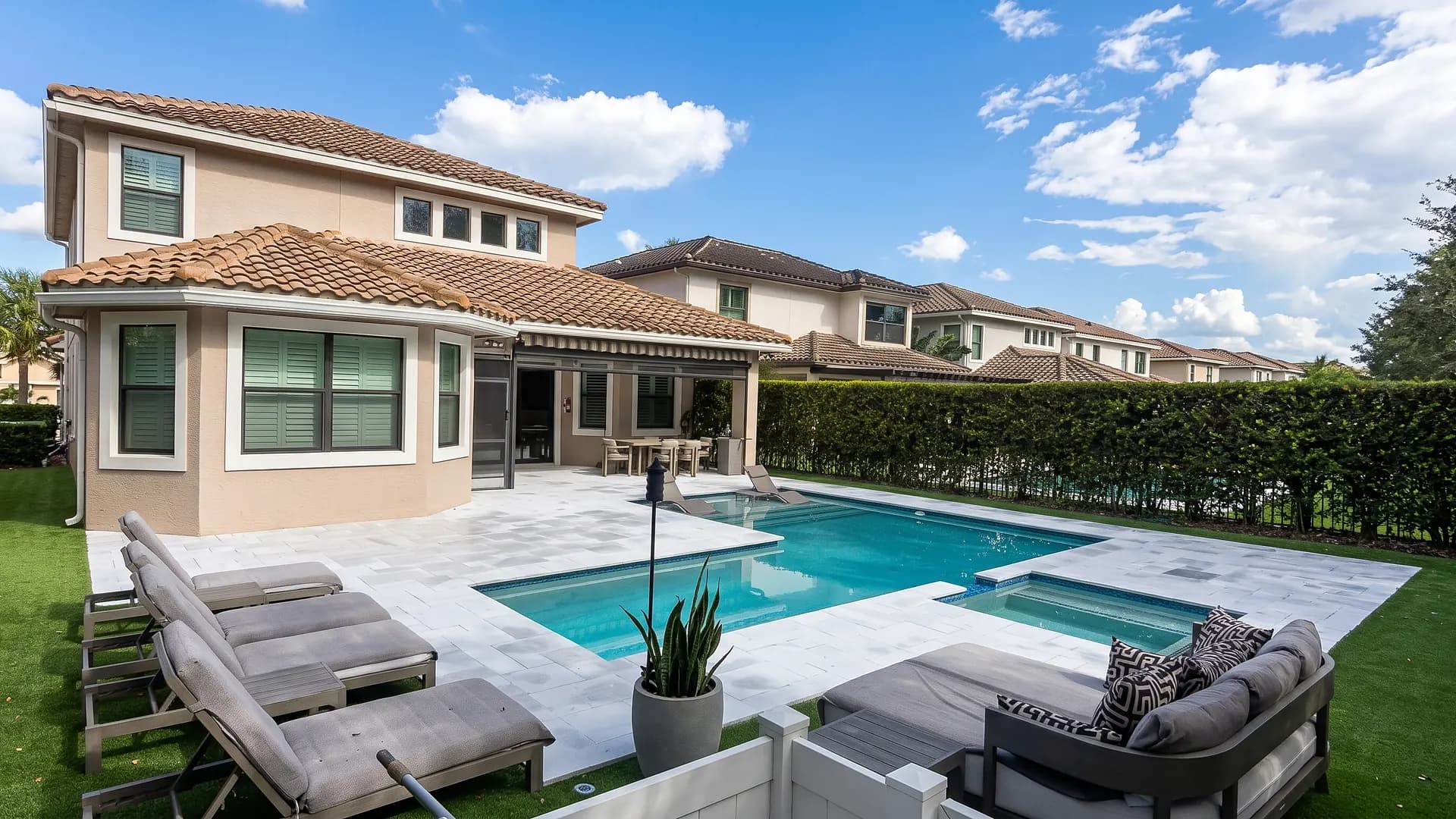 Light stone pool deck around a pool and spa